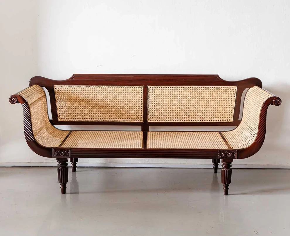 A carved solid wood sofa with hand-woven cane seating